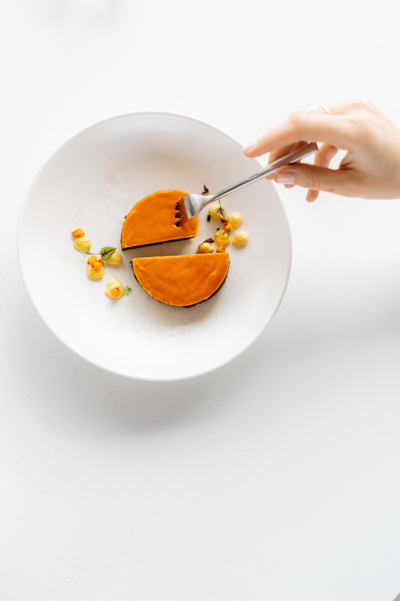 Chef arranging plated dish in modern kitchen